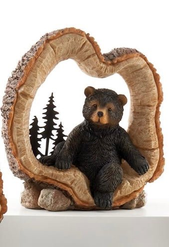Bear sitting in a log figurine
